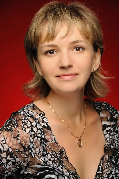 Portret van het jonge meisje op een rode achtergrond — Stockfoto