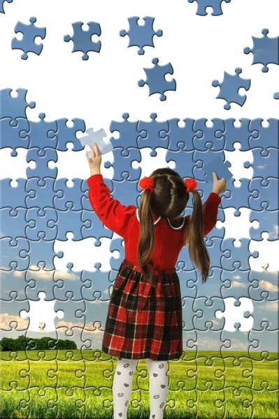 Девушка собирает большую головоломку — стоковое фото