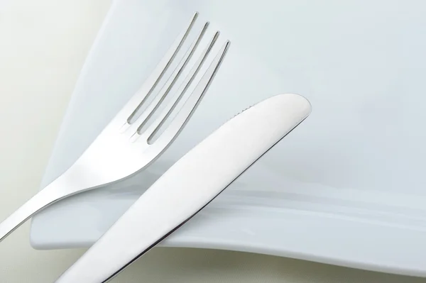 Вилка и нож лежат на тарелке — стоковое фото