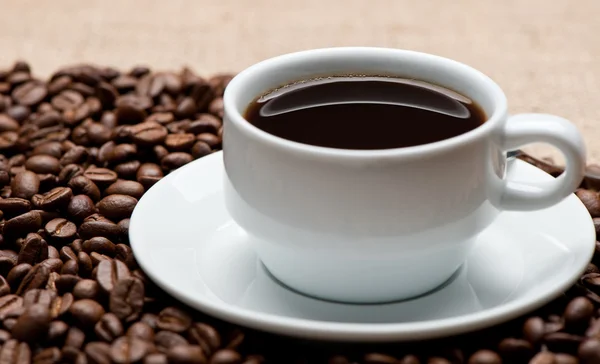 Tasse Kaffee auf Kaffeekörnern — Stockfoto
