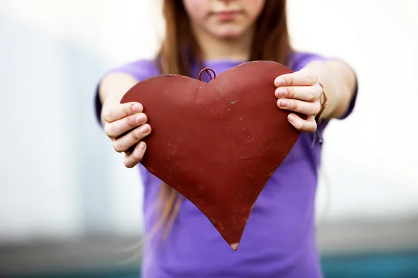 Criança mostra um coração vermelho - espaço para texto — Fotografia de Stock