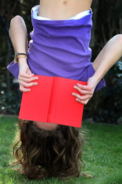 Ein Kind liest ein Buch - kopfüber — Stockfoto