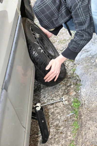 Um pneu de carro é mudado — Fotografia de Stock
