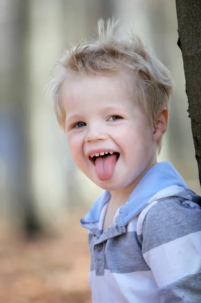 그의 혀에 밖으로 기지개 하는 어린 소년 — 스톡 사진