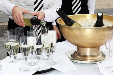 Two waiters fill glasses of champagne clipart