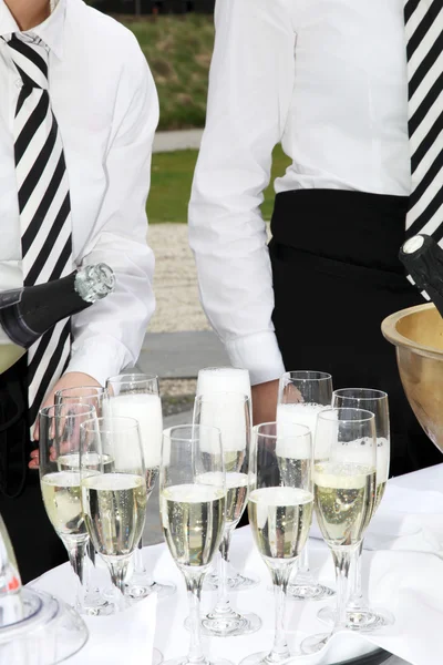 Dois garçons enchem copos de champanhe — Fotografia de Stock