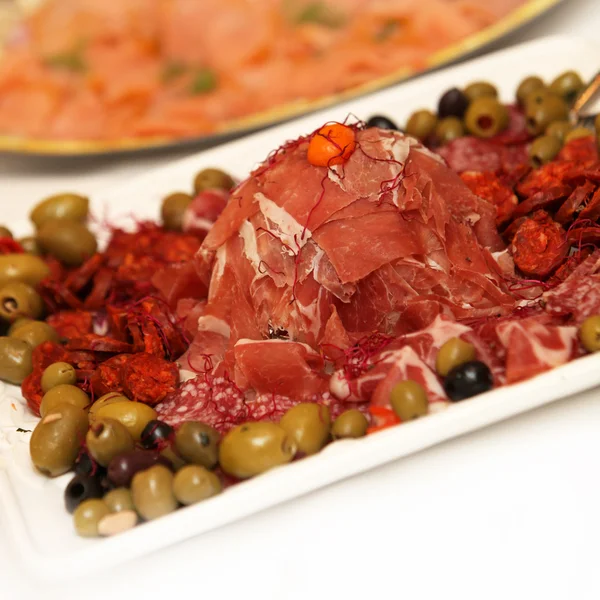 Ветчина, салями на тарелке, украшенной оливками — стоковое фото