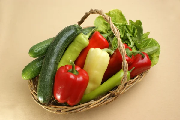 Салат и свежий перец в корзине — стоковое фото