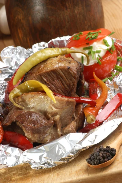 Braised meat in tinfoil with paprika — Stock Photo, Image