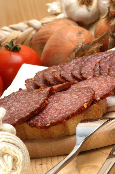 Some slices salami on a timber board — Stock Photo, Image