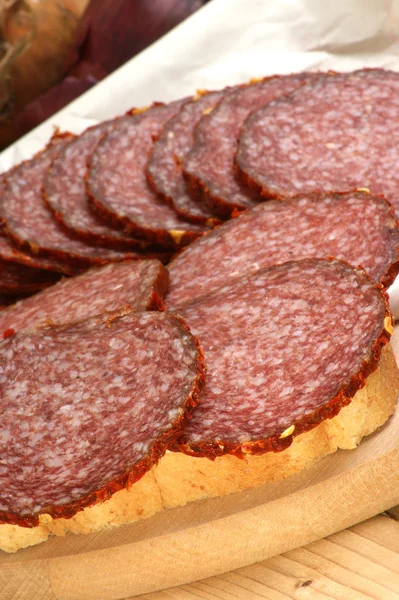 Slices salami on a timber board — Stock Photo, Image