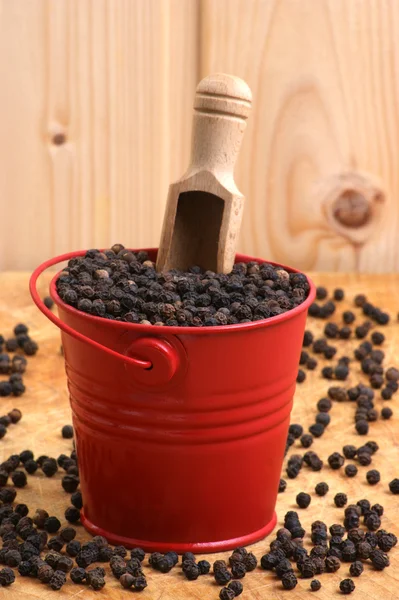 Černý pepř kukuřice v červený kbelík — Stock fotografie