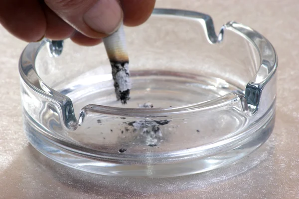 Cigarrillo en un cenicero de vidrio — Foto de Stock
