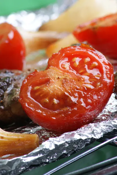 Organic tomato and meat on a grill — Stock Photo, Image