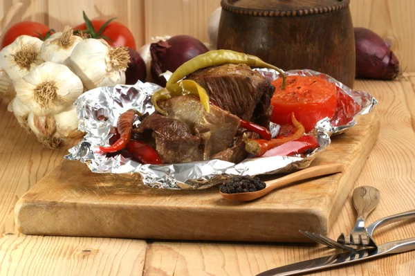 Braised meat in tinfoil with grilled paprika — Stock Photo, Image