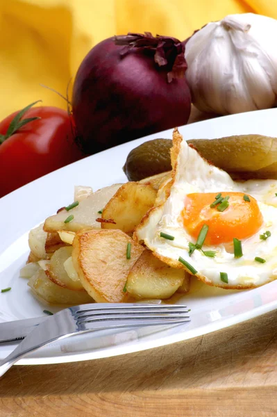 Жареный картофель с яичницей на тарелке — стоковое фото