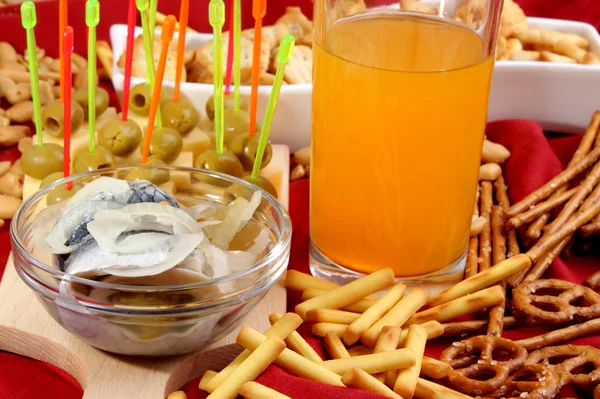 Soft drink in a glass and snacks in the background — Stock Photo, Image