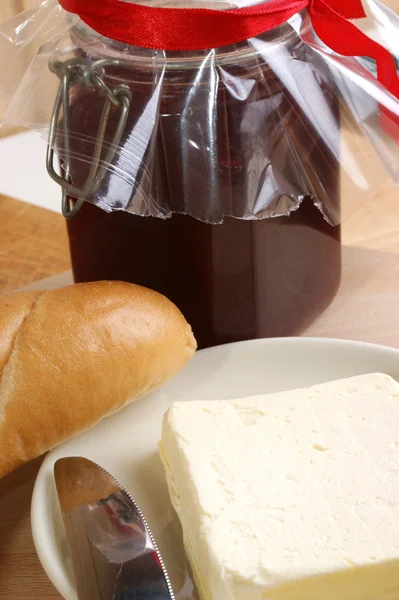 Ontbijt met broodje en organische boter — Stockfoto