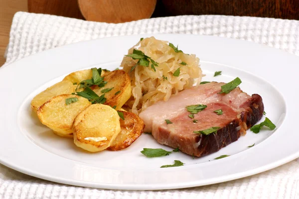 Gerookte varkensvlees met organische zuurkool en aardappel — Stockfoto