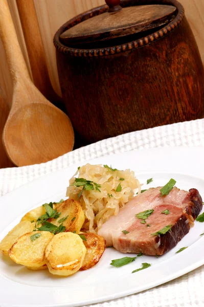 Копчена свинина з органічною квашеною капустою та картоплею — стокове фото