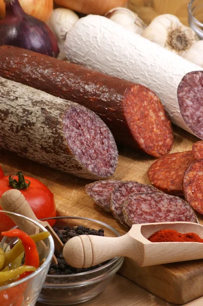 Salami and some slices salami on a timber board — Stock Photo, Image