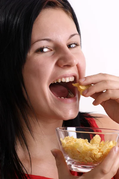 Młoda kobieta jedzenie płatki kukurydziane z miski — Zdjęcie stockowe