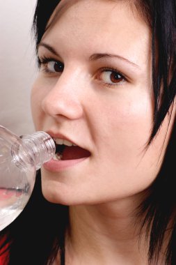 genç bir kadın suyu şişeden içer.