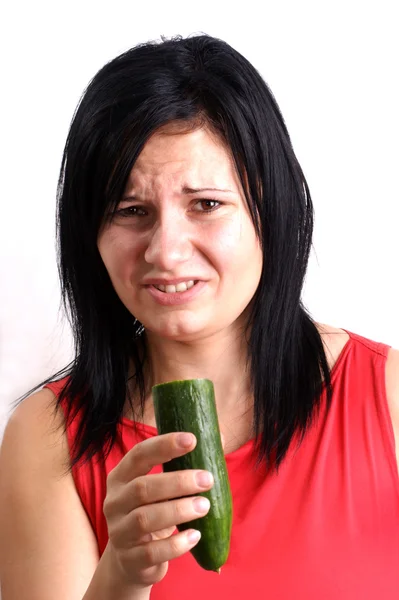 Uma jovem mulher comendo um pepino orgânico — Fotografia de Stock