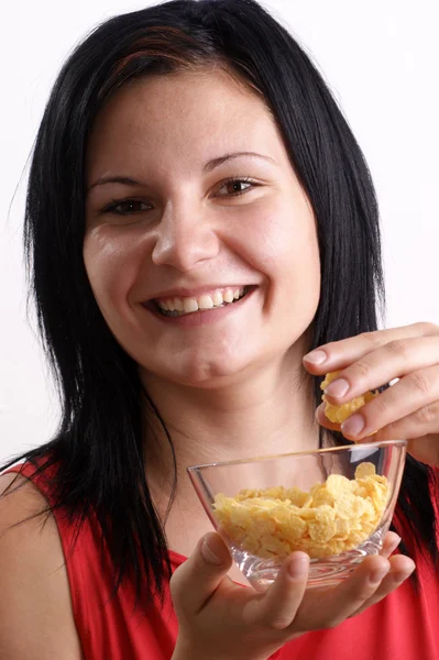Uma jovem mulher comendo flocos de milho de uma tigela — Fotografia de Stock