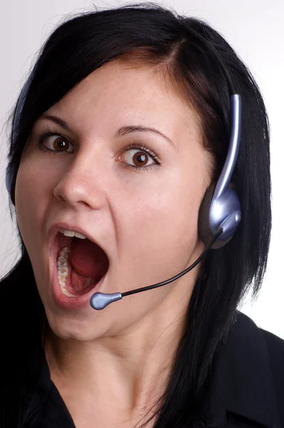 Eine junge Frau mit offenem Mund und Headset — Stockfoto