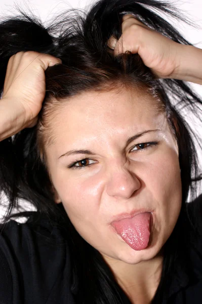 Uma jovem agressiva mostra sua língua — Fotografia de Stock