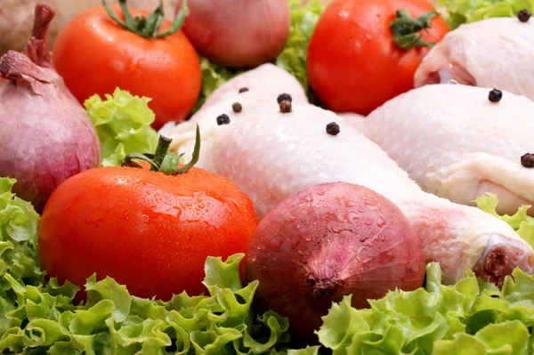 Surové organické kuřecí stehno s cibulí a rajčaty — Stock fotografie