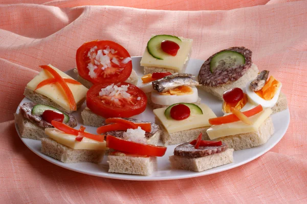Some party nibbles on a white plate — Stock Photo, Image