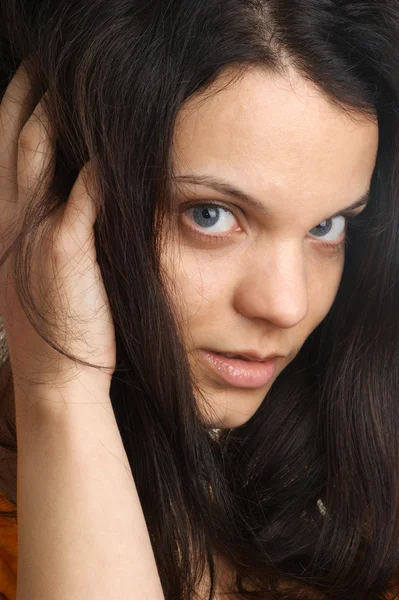 Uma jovem está brincando com seu cabelo comprido — Fotografia de Stock
