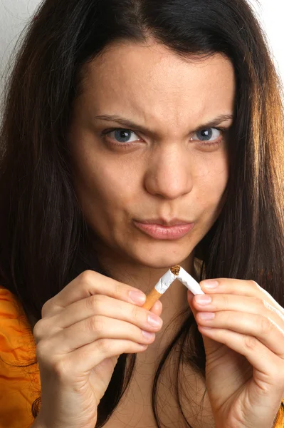 Uma jovem mulher segura um cigarro no dedo — Fotografia de Stock