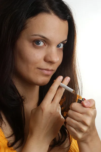 Μια νεαρή γυναίκα κρατά ένα τσιγάρο στο δάχτυλό της — Φωτογραφία Αρχείου