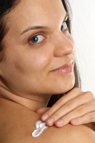 En ung kvinna använder sun crème — Stockfoto