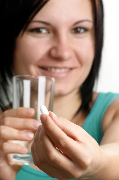 Um analgésico numa mão e um copo de água — Fotografia de Stock