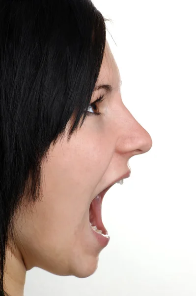 Uma jovem está gritando com a boca aberta — Fotografia de Stock