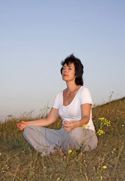 Perempuan kekhawatiran dengan yoga pada matahari terbenam dari siang hari. . — Stok Foto