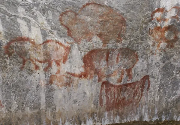 Rock målningar av gamla i en grotta Stockbild