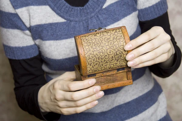 Руки с декоративной деревянной коробкой — стоковое фото