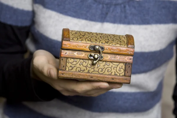 Mani che tengono una scatola di legno decorativa — Foto Stock