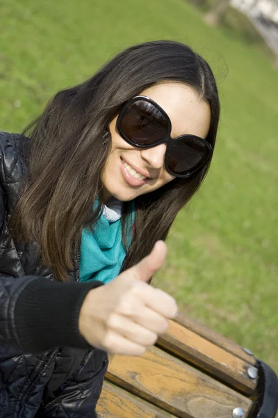 Piękna dziewczyna w parku uśmiechnięty. kciuk — Zdjęcie stockowe