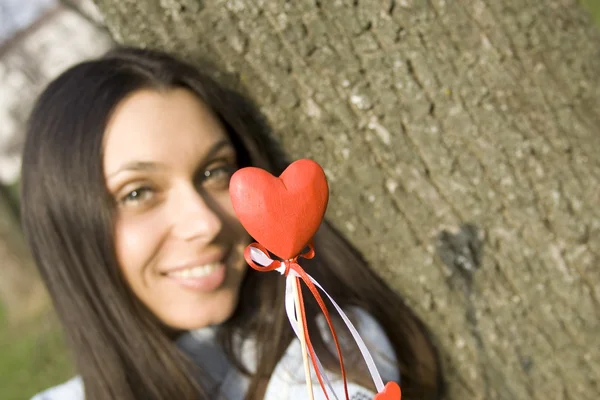 Beautiful girl with a red heart — Stock Photo, Image