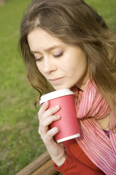 Γυναίκα σε ένα πάρκο πίνοντας καφέ — Φωτογραφία Αρχείου