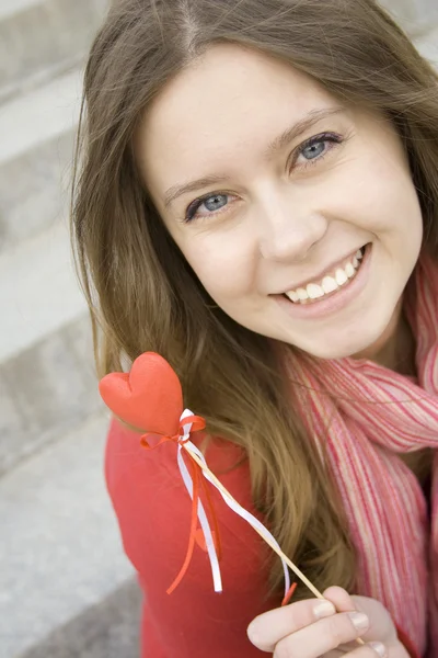 Vacker flicka med ett rött hjärta — Stockfoto