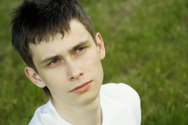 Genç adam parkta oturan — Stok fotoğraf
