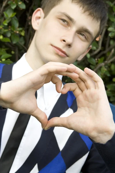 Adolescent garçon faire coeur forme avec mains — Photo