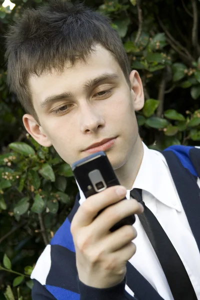 Jovem olhando para o telefone celular — Fotografia de Stock
